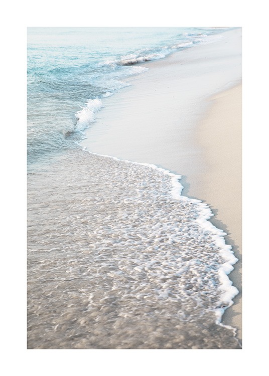  – Foto van een strand met licht zand en golven die op het strand slaan