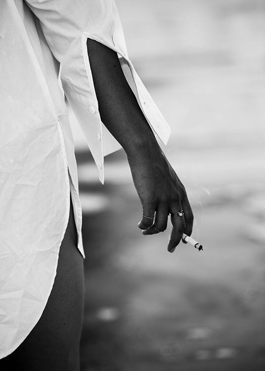 — Zwart-witfoto van een meisje aan het water dat een sigaret vasthoudt