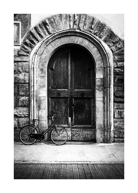  - Zwart-wit foto van een rustieke deur met een fiets ervoor