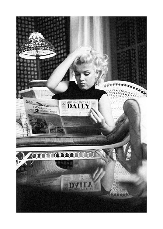  – Zwart wit foto van het icoon Marilyn Monroe terwijl ze een krant leest op de bank