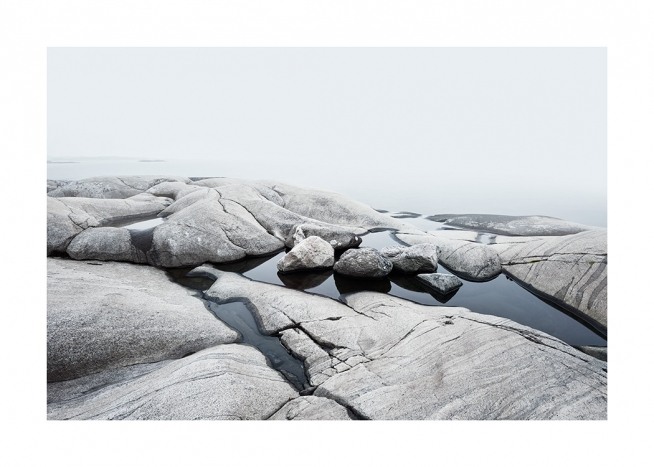  – Foto van een kustlijn met gladde rotsen en water ertussen