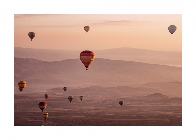  - Foto van een landschap tijdens zonsondergang met luchtballonnen in de lucht