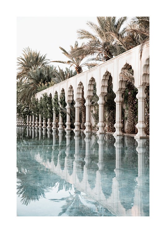  - Foto van witte pilaren en gewelfde bogen naast een zwembad met palmbomen op de achtergrond