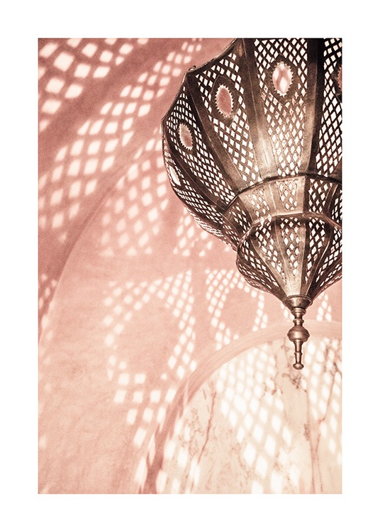  - Foto van een roze ruimte met een metalen lamp die een patroon op de wanden reflecteert