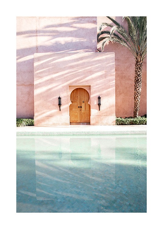  - Foto van een palmboom naast een roze gebouw met een zwembad ervoor