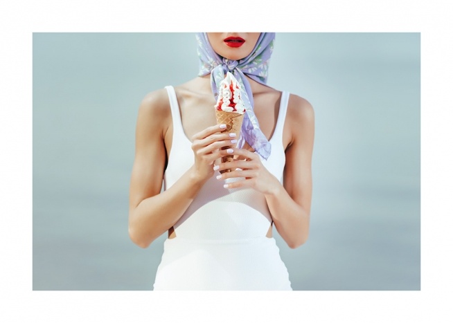  – Retro foto van een vrouw met een ijsje in haar hand die een wit badpak en een blauwe sjaal draagt