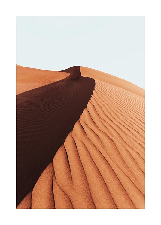 – Foto van een zandduin in een woestijn met een lichtblauwe lucht erachter