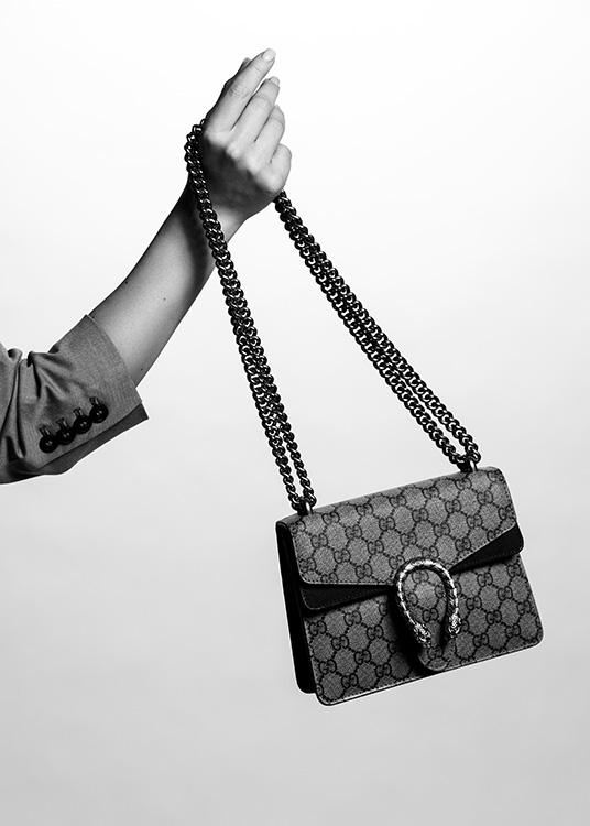  – Zwart wit foto van een Gucci handtas vastgehouden door de hand van een vrouw