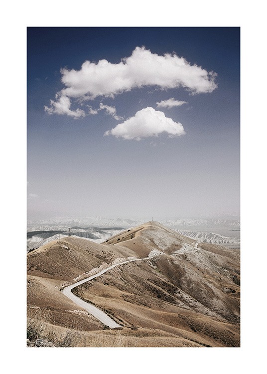  – Foto van een bergketen met een weg erdoorheen, met wolken en een blauwe hemel op de achtergrond
