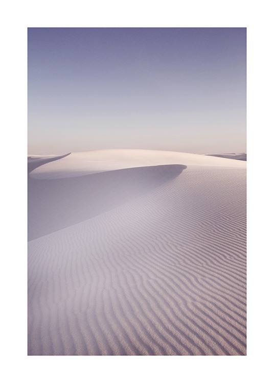  – Foto van zandduinen in een woestijn met een geribbeld oppervlak, met een blauwe hemel op de achtergrond