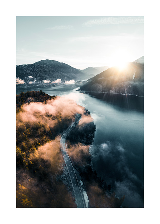  – Foto van een landschap met een weg tussen een bos en meer met bergen en de zon op de achtergrond