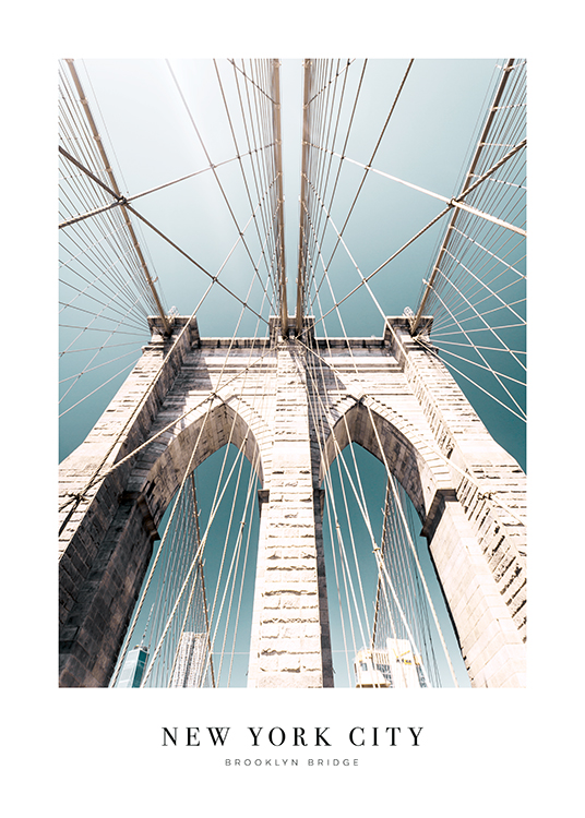  – Foto van Brooklyn Bridge van onderaf gezien, tegen een blauwe hemel en tekst aan de onderkant
