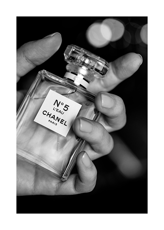  – Zwart-wit foto van een fles Chanel No5 parfum vastgehouden door een hand