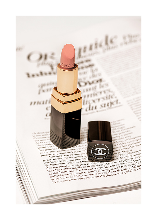  – Foto van een Chanel lippenstift in lichtroze met de pagina van een boek eronder