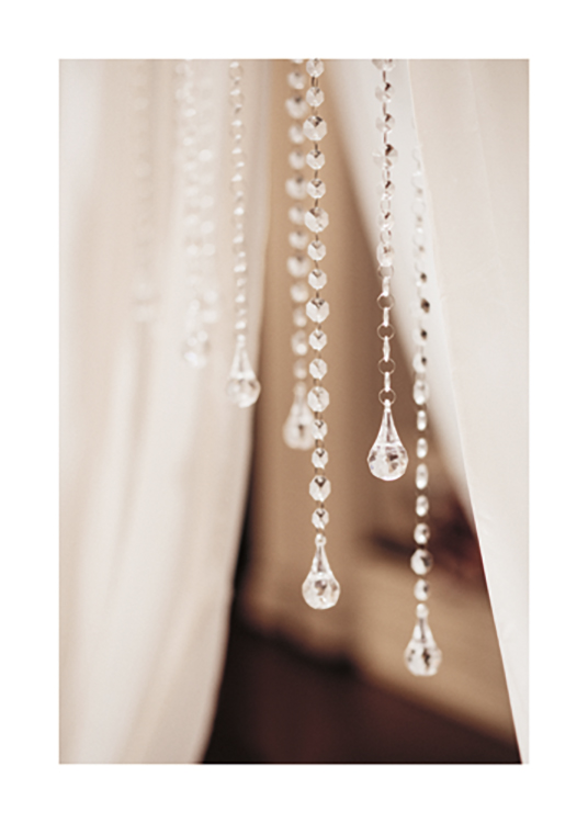  – Foto met close-up van een aantal kristallen hangers met witte gordijnen erachter