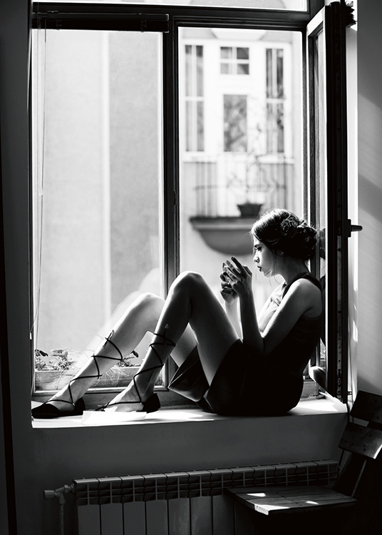  – Zwart-witfoto van een vrouw die in een open raam zit en een kop vasthoudt