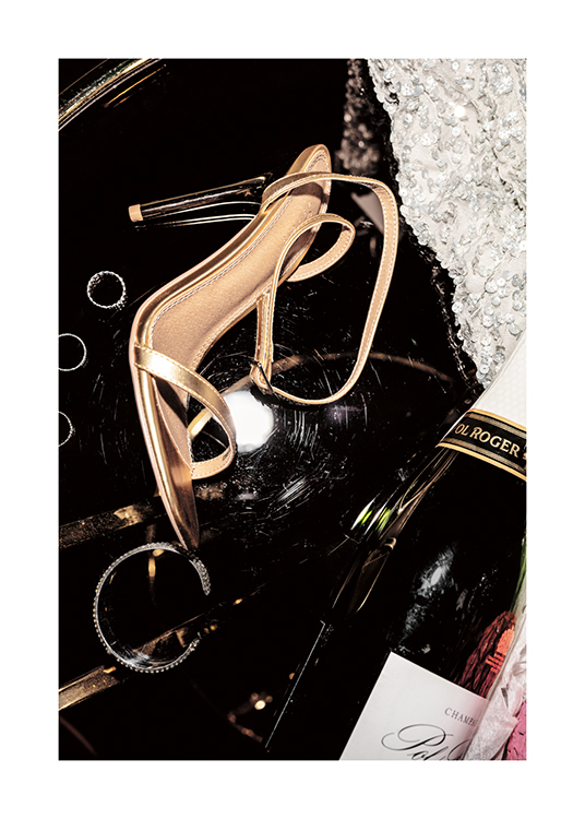  – Een foto van champagne, gouden hakken, zilveren sieraden en een jurk met pailletten