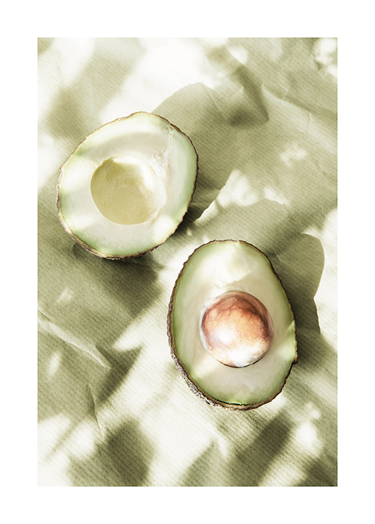  – Foto van een paar avocadohelften waar schaduwen overheen vallen, die op groen papier liggen