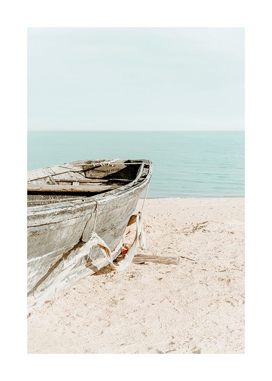  – Foto van een oude boot in het zand op een strand met de lucht en oceaan op de achtergrond