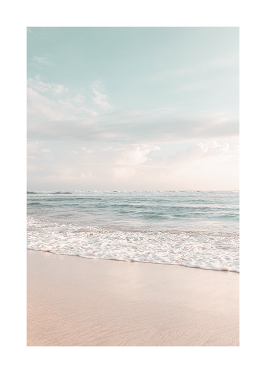  – Foto van een lichtblauwe oceaan met op de voorgrond het strand en een lichtblauwe lucht op de achtergrond