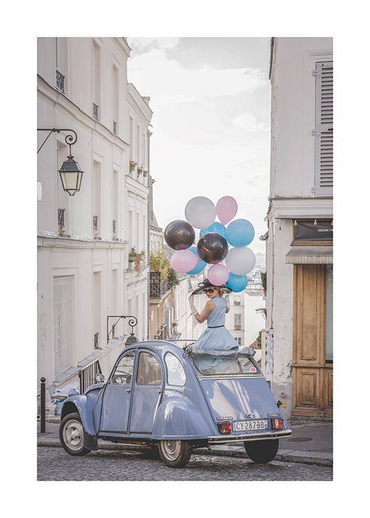  – Foto van een vrouw die een ballonnen vasthoudt terwijl ze in een blauwe vintage auto zit