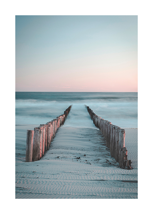  – Foto van twee rijen houten palen die vanaf het strand een mistige oceaan in lopen