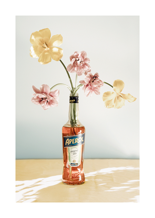  – Foto van bloemen in roze en geel in een fles aperol