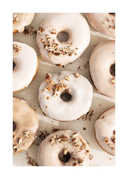  – Foto van een aantal donuts met beige en witte glazuur en noten topping