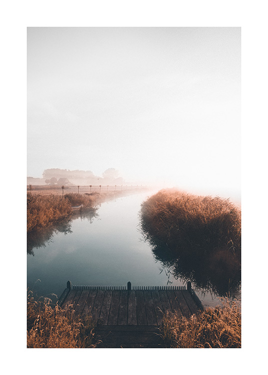  – Foto van een kalm meer met een mistig landschap op de achtergrond en een steigertje op de voorgrond