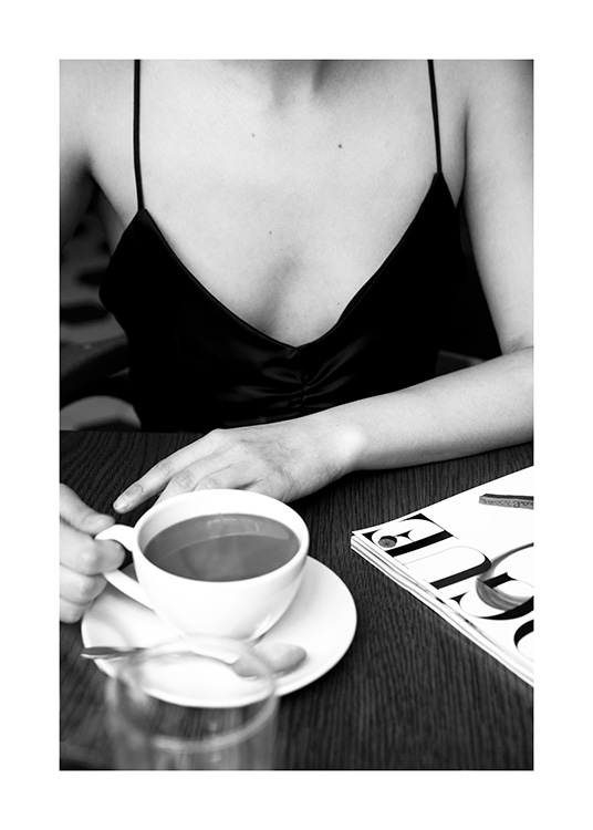  – Zwart-witfoto van een vrouw die in een café zit met een koffiekopje op tafel