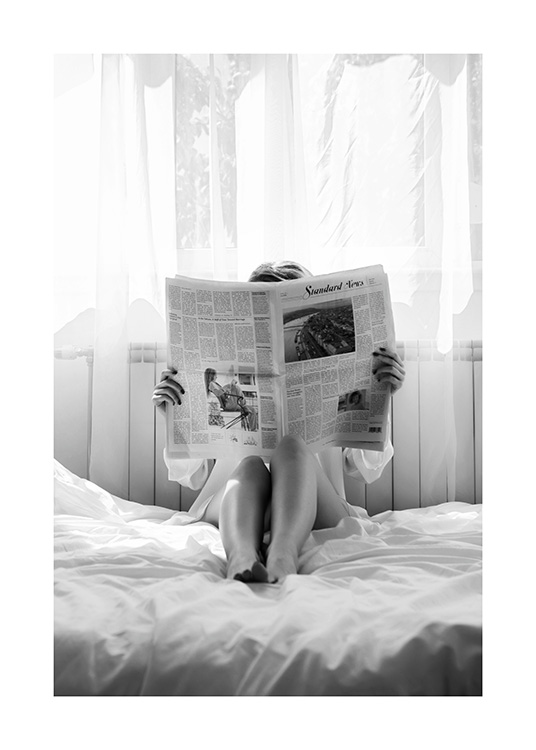  – Zwart-witfoto van een vrouw die in bed een krant leest