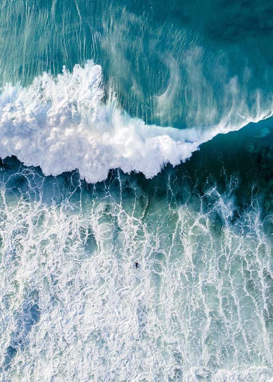  – Foto van bovenaf van een oceaan met grote golf die naar een surfer komt